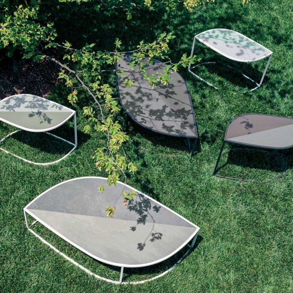 Image aerial view of different sizes and finishes of RODA Leaf modern garden coffee tables on lawn, in light and shade beneath branches of tree
