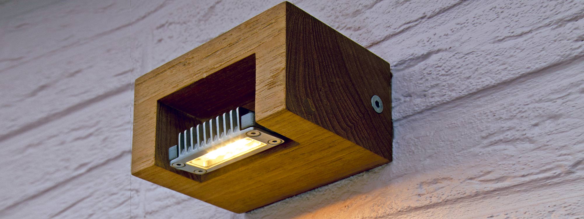 Image of Royal Botania log adjustable outdoor wall light in teak and stainless steel, shown on whitewashed brick wall