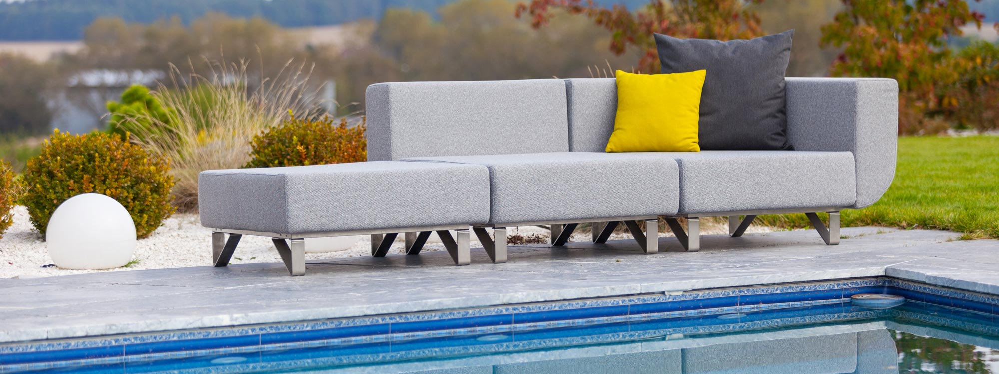 Image of Todus Lotos garden sofa with brushed stainless steel frame and light grey cushions on poolside