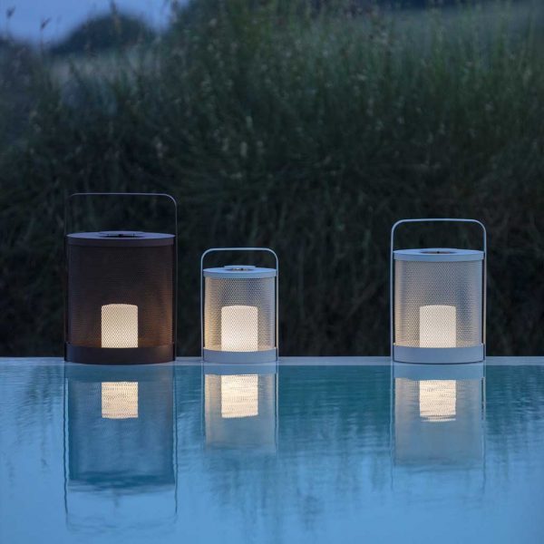 Image of lit Luci LED outdoor lanterns reflected in water of swimming pool