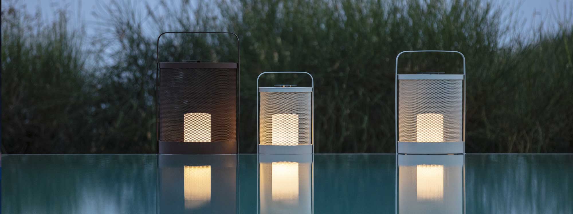 Luci modern garden lanterns reflected in water of swimming pool