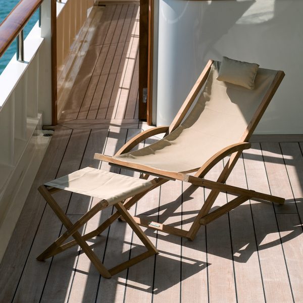 Image of Beacher foldaway teak chair with cappuccino seat sling by Royal Botania on deck of yacht