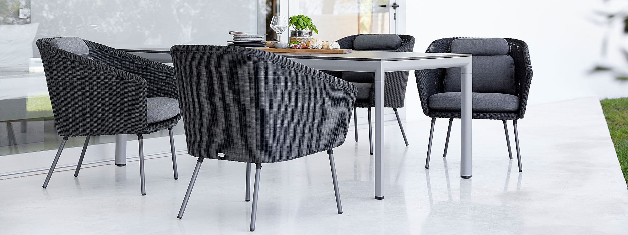 Image of Caneline Drop garden table and Mega dining chair in Graphite weave with Grey Air Touch cushions