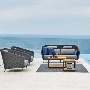 Image of Cane-line Level Low Tables & Mega woven garden lounge furniture shown on sleek terrace with sea in the background