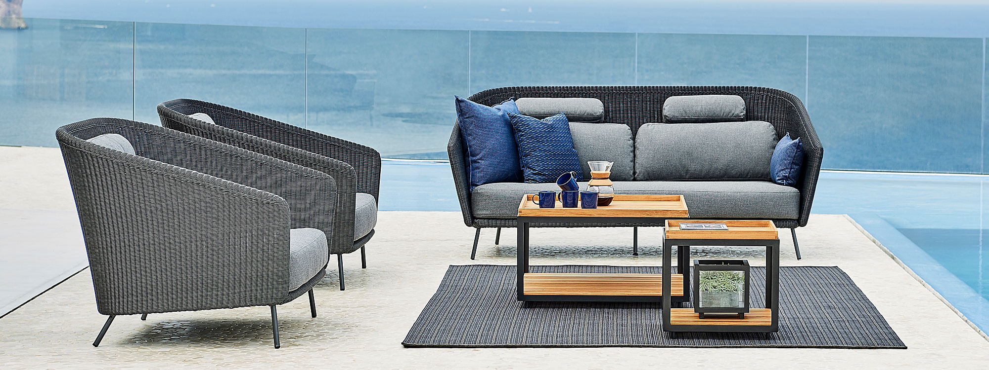 Image of Cane-line Mega graphite lounge chairs and 2 seat garden sofa with Level teak low tables in the center