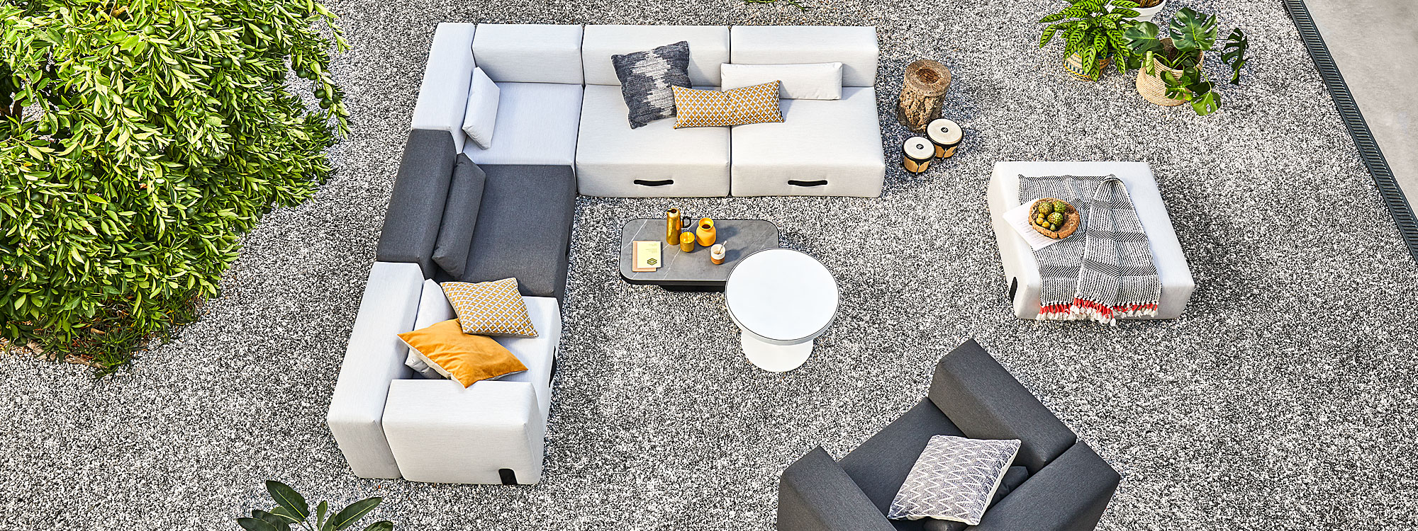 Birdseye view of Miami luxury garden sofa in Grey & Anthracite, shown on gravel beneath orange trees