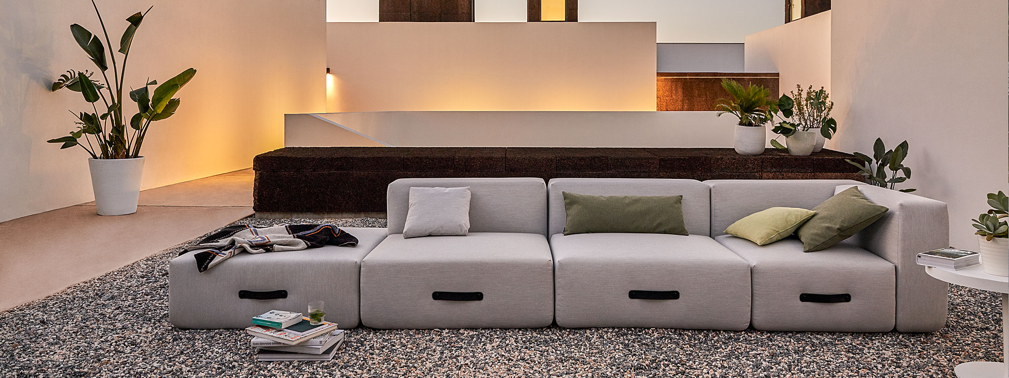 Dusk shot of Miami garden sofa in minimalist Mediterranean courtyard