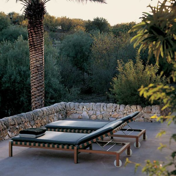 Image of RODA Mistral teak sun loungers on Mediterranean terrace next to large palm tree