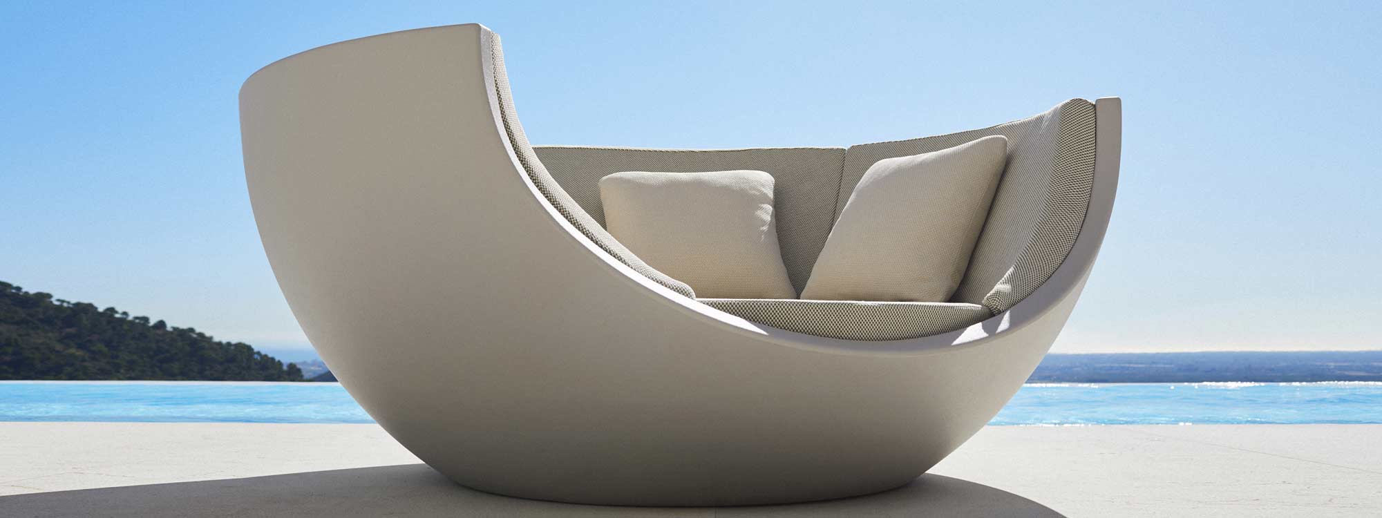Image of Vondom Moon modern garden daybed with horizon swimming pool and hills in the background