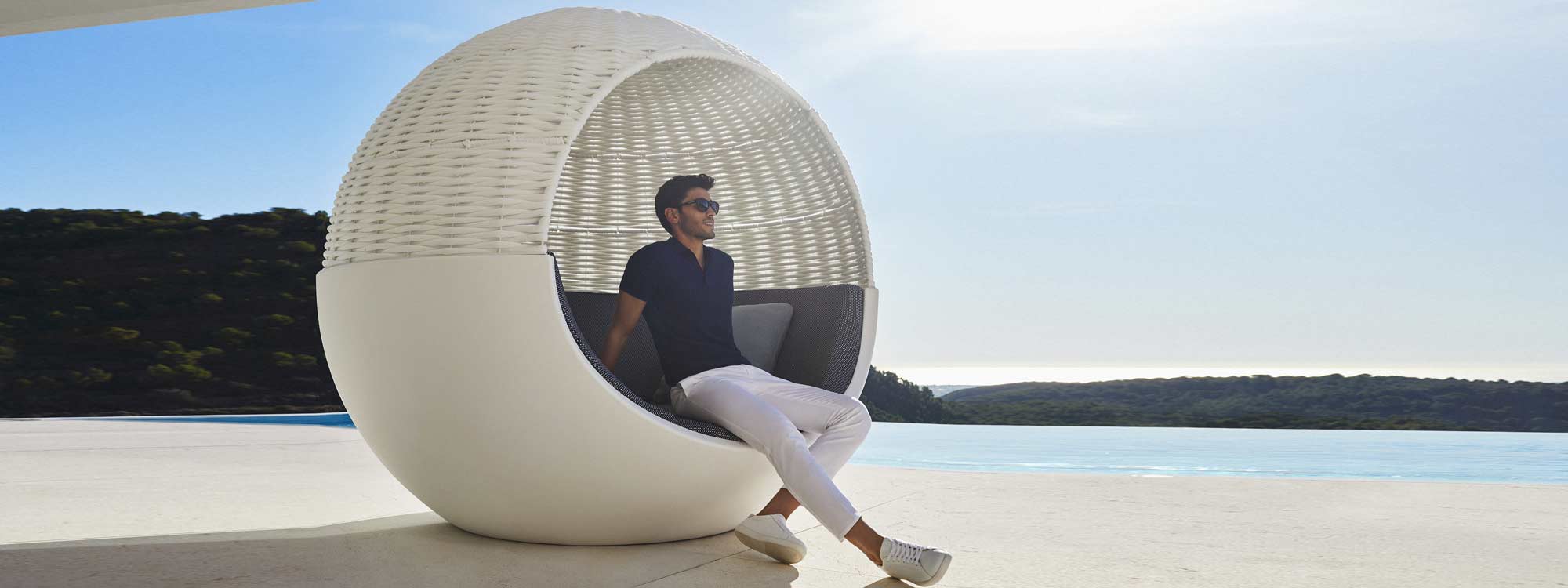Image of man sat inside Vondom Moon spherical outdoor daybed on sunny terrace