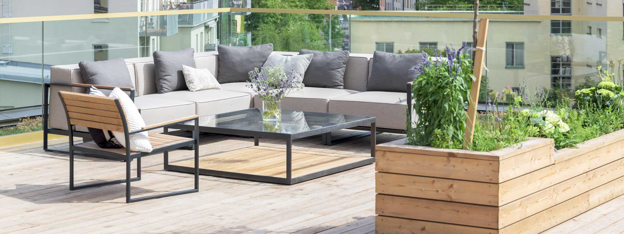Image of Roshults Moore modular garden corner sofa on terrace with rooftops and buildings in the background