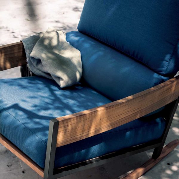 Image of RODA Nap outdoor rocking chair in teak and smoke colored stainless steel, with blue back, seat and bolster cushions