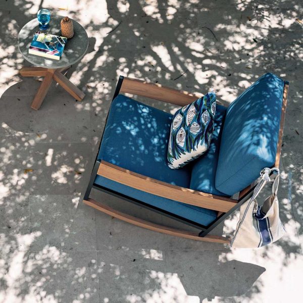Image of aerial view of RODA Nap exterior rocking chair in teak and smoke-colored stainless steel, with blue cushions