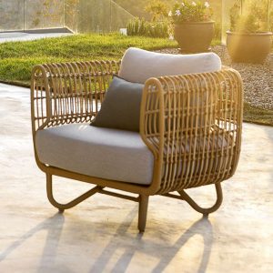 Image of sunset casting long shadows on terrace with Caneline Nest lounge chair in Natural Cane-line Weave with Taupe cushions