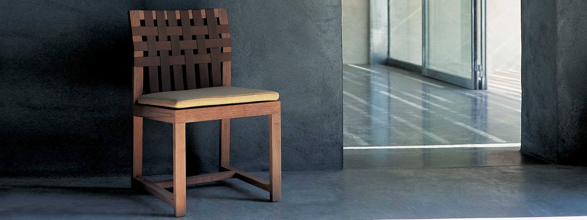 Network teak chair by Rodolfo Dordoni on polished concrete floor.