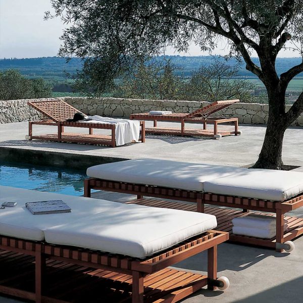 Network teak sunbeds next to swimming pool with Italian countryside in background