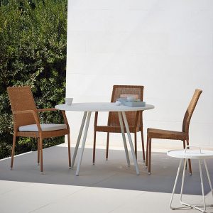 Image of Cane-line Newman cane garden chairs in natural finish with Area round garden dining table in white