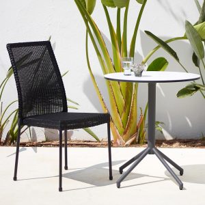 Image of black Newport garden chair next to Cane-line bistro table on sunny white-washed terrace