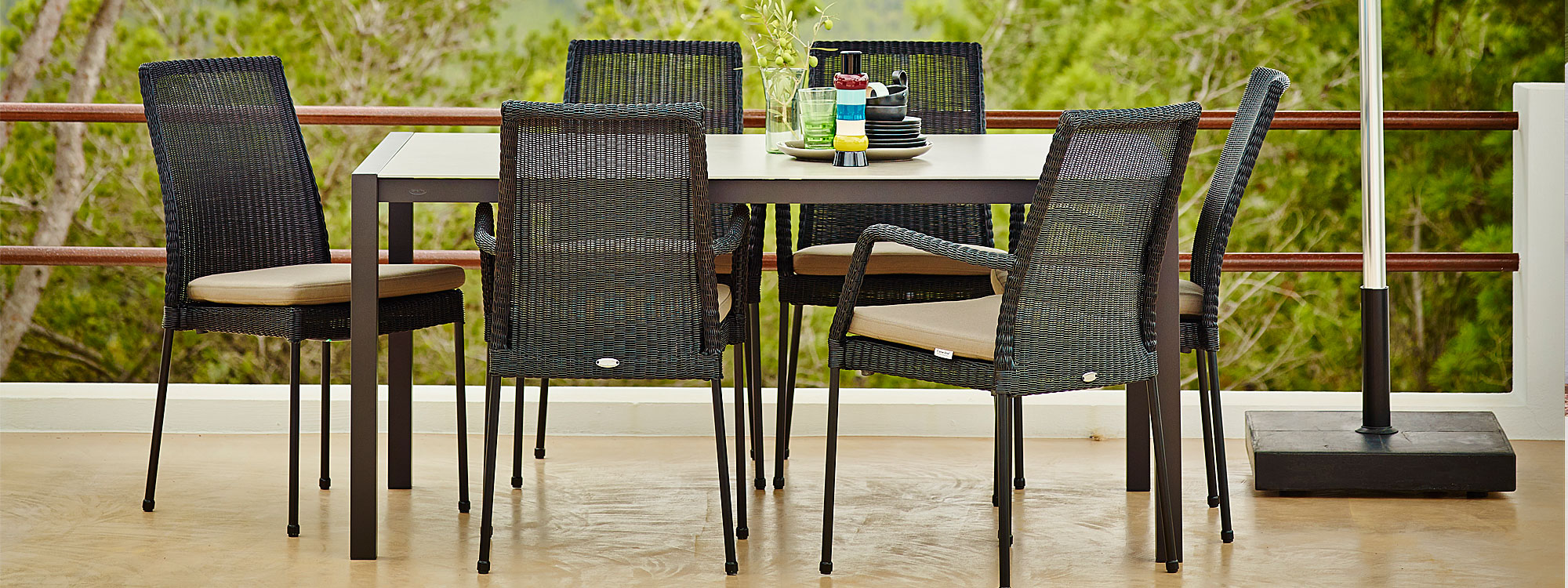 Image of black Newport stacking garden chairs around Cane-line table
