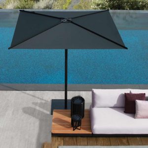 Image of Royal Botania Vigor Lounge sofa & black Oazz parasol beside swimming pool.