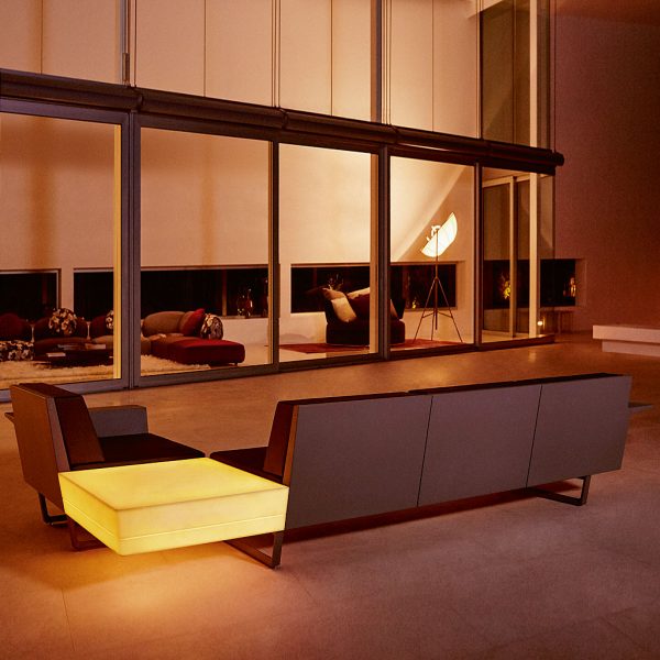 Nighttime interior image of Vondom Delta modern corner sofa with illuminated corner table