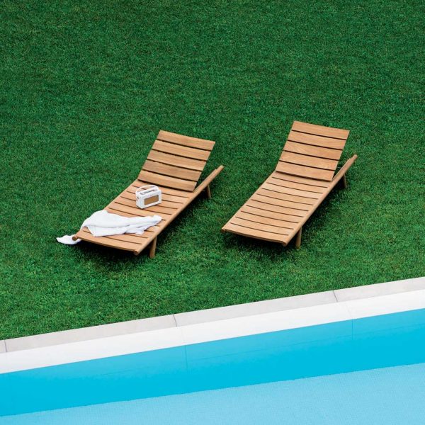 Pair of Orson modern teak sun loungers on grassy lawn next to swimming pool