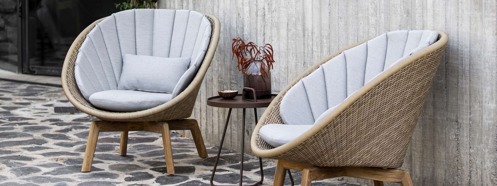 Image of pair of Peacock lounge chairs in natural Cane-line weave with taupe cushions