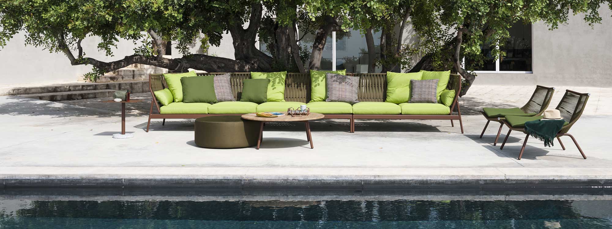 Piper modern garden sofa and Laze outdoor lounge chairs on poolside in front of large tree