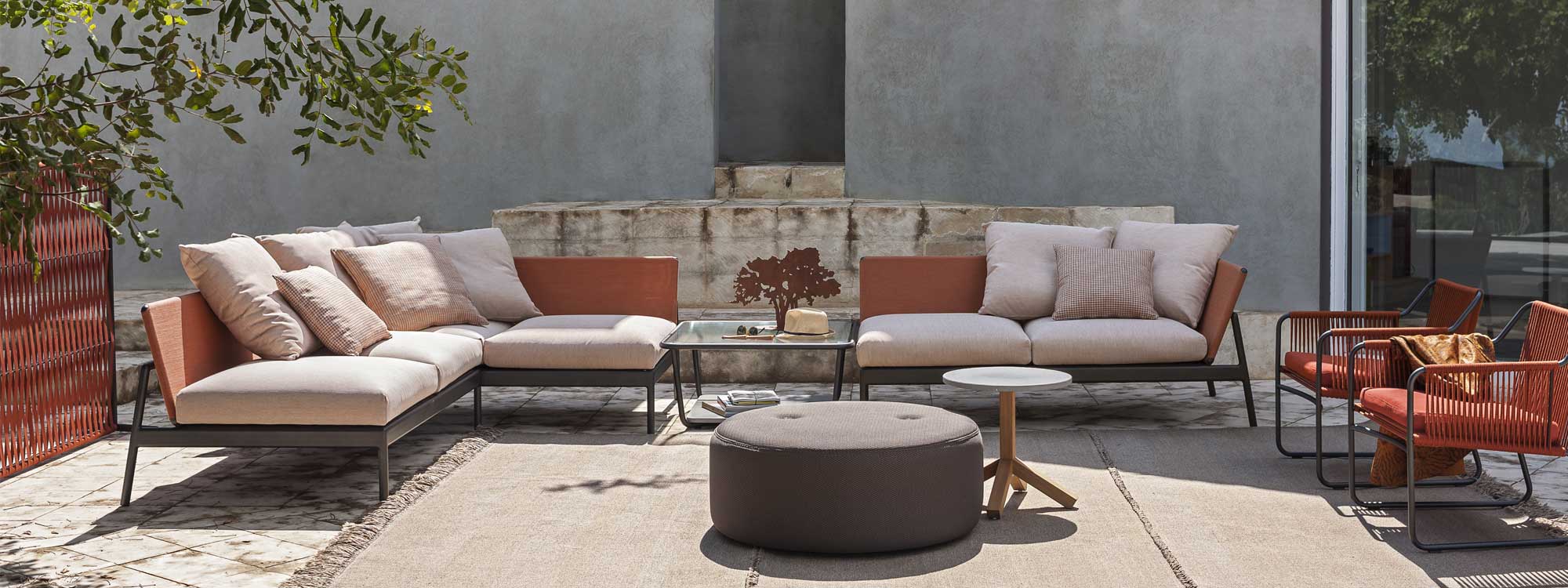 Piper modern garden corner sofa and Harp outdoor lounge chairs in vibrant orange, shown with Double outdoor pouf and Root exterior low table