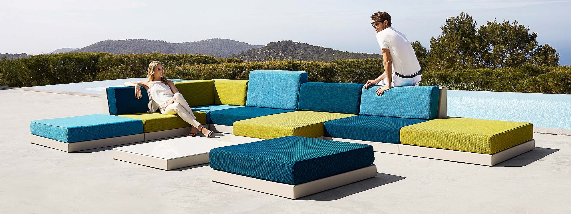 Image of man and woman relaxing on Vondom Pixel modern garden sofa with cushions in range of colours