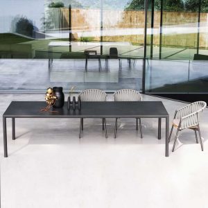 Image of RODA Plein Air large rectangular garden table with Piper chairs in front of large floor to ceiling glass doors