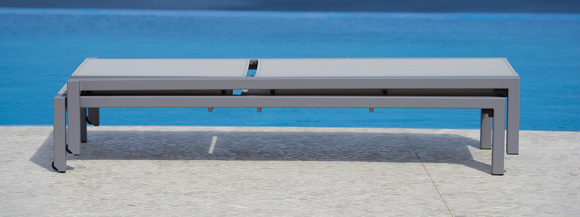 Image of pair of stacked Relax sun loungers in light-grey by Cane-line on poolside