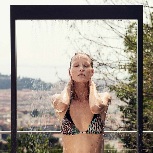 Image of woman cooling off beneath Roshults minimalist garden shower