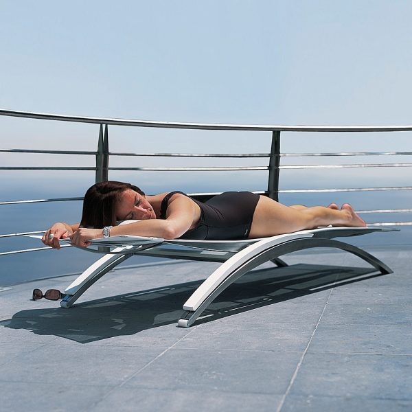 Image of woman lying on her front on fully reclined OZON sun lounger by Royal Botania