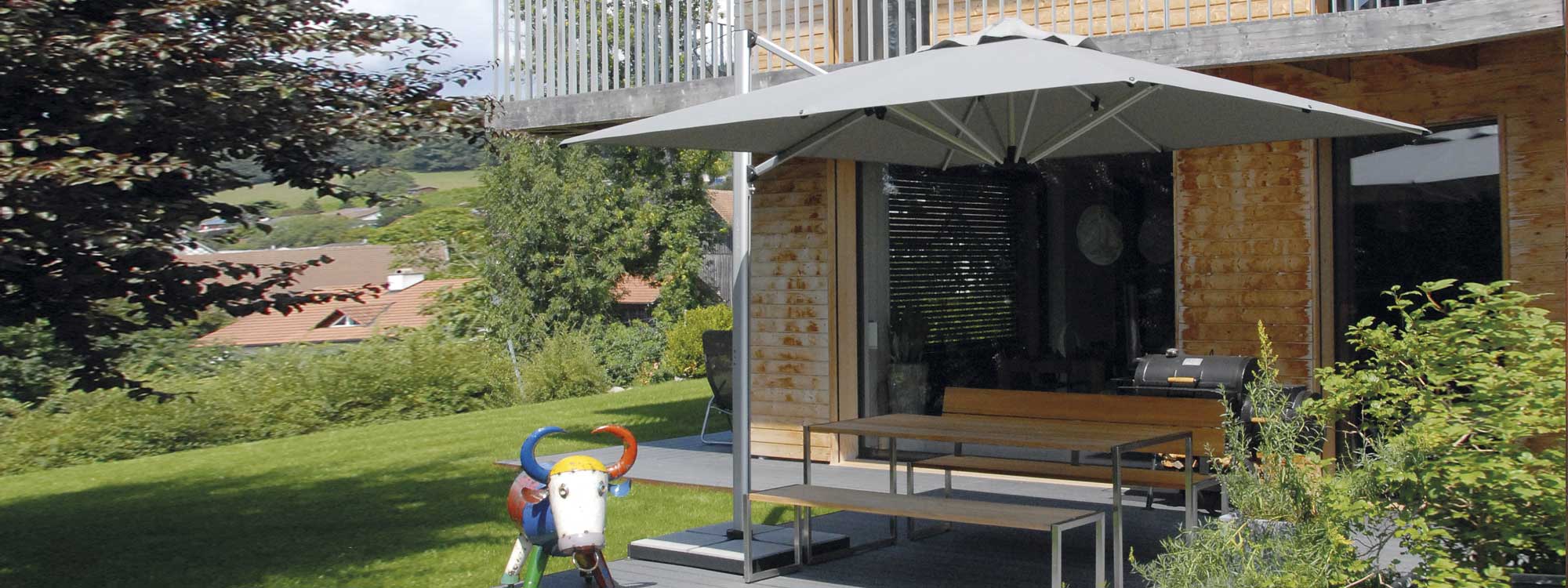 Image of Shademaker Sirius tilting and rotating garden parasol over dining table and benches on private terrace