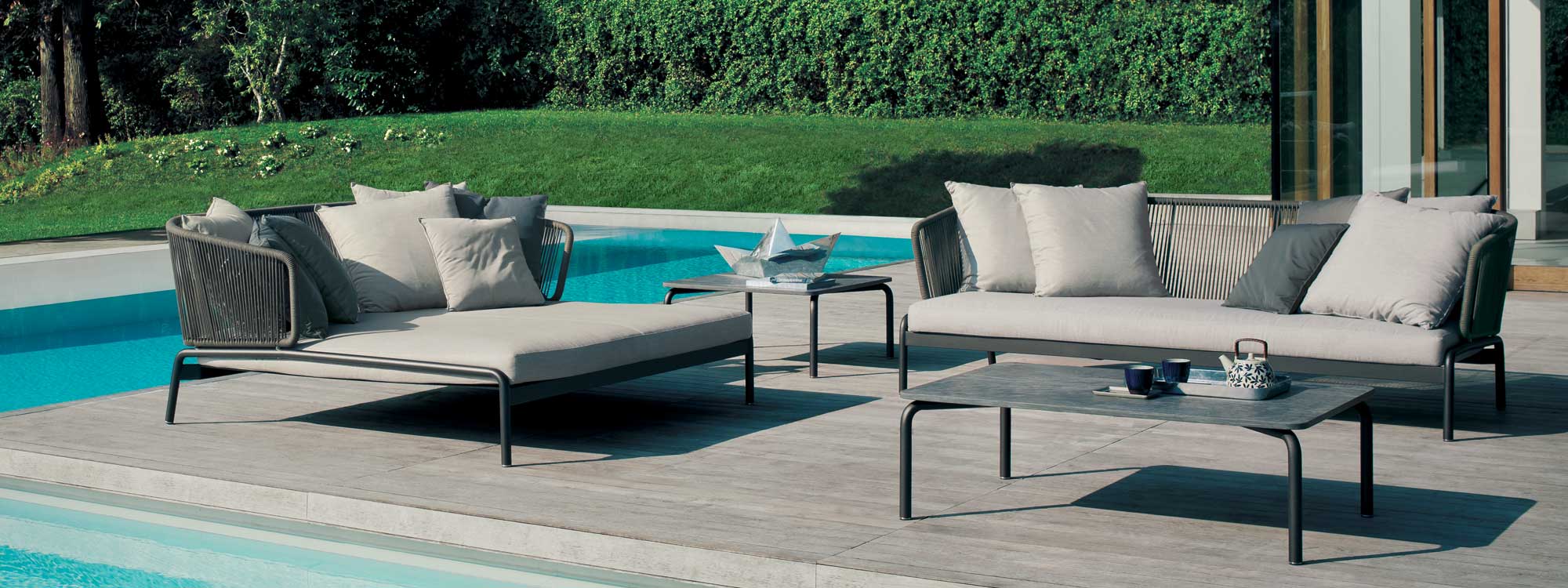 Image of RODA Spool 3 seat garden sofa and twin daybed with grey frames and grey cushions, shown on poolside terrace