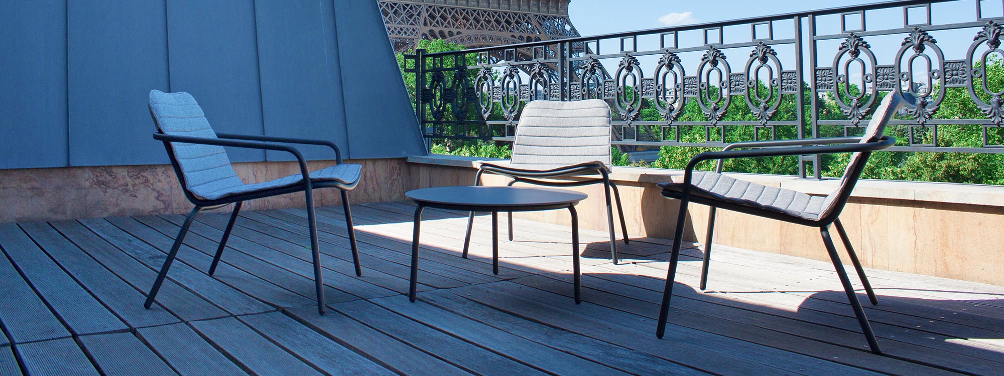 Fantastic shot of Starling outdoor lounge chairs on Parisian roof top terrace with Eiffel Tower in background