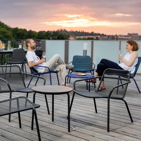 Image of rooftop terrace at dusk with couple relaxing in Todus Starling outdoor lounge chairs