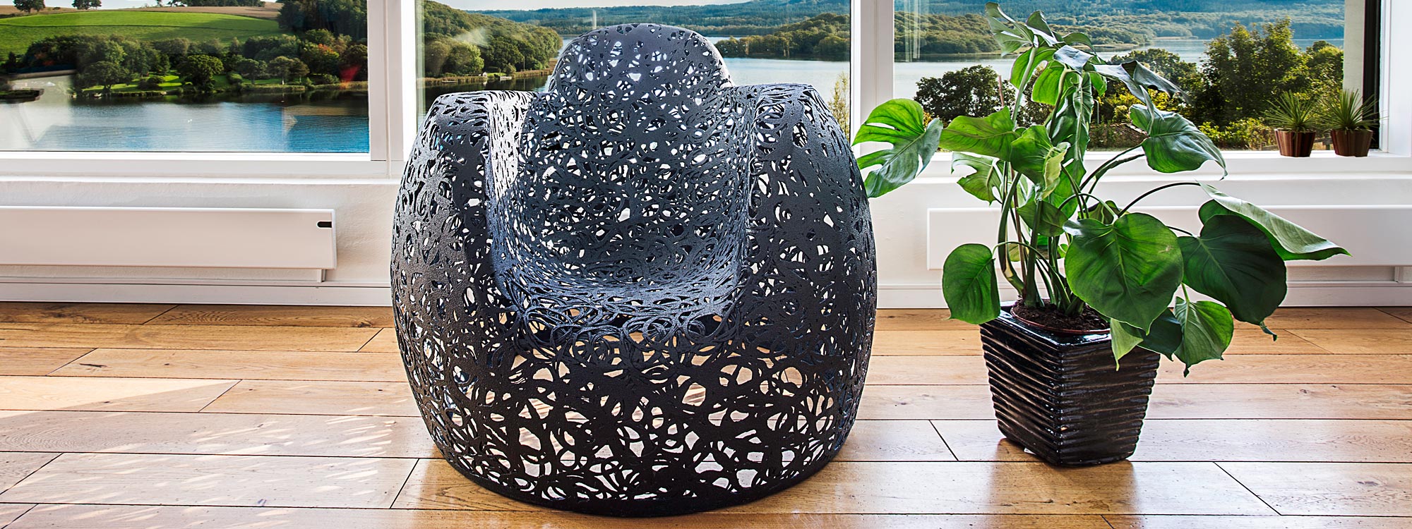 Image of Stellar black modern armchair by Unknown Nordic, shown in a house over-looking a lake and rolling countryside