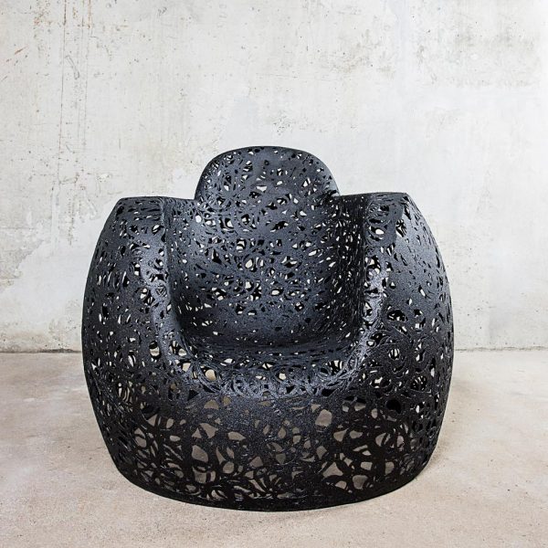 Image of black Stellar armchair by Unknown Nordic furniture, shown against concrete background and floor.