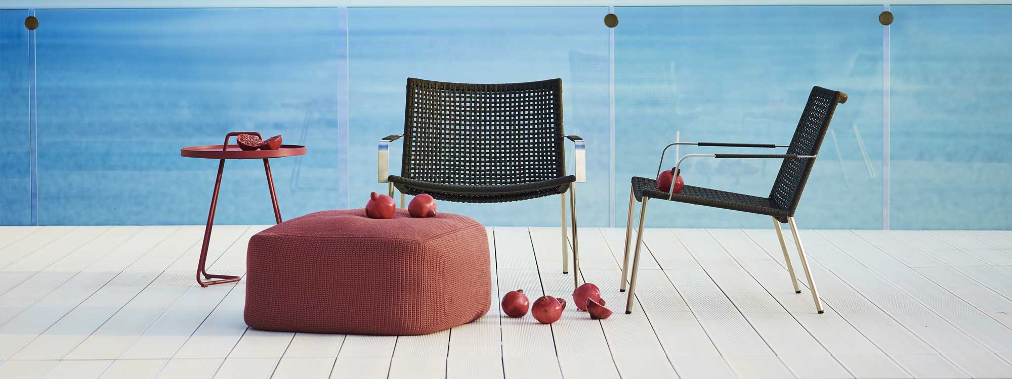 Image of pair of Straw stacking lounge chairs and Divine pouf by Caneline outdoor furniture