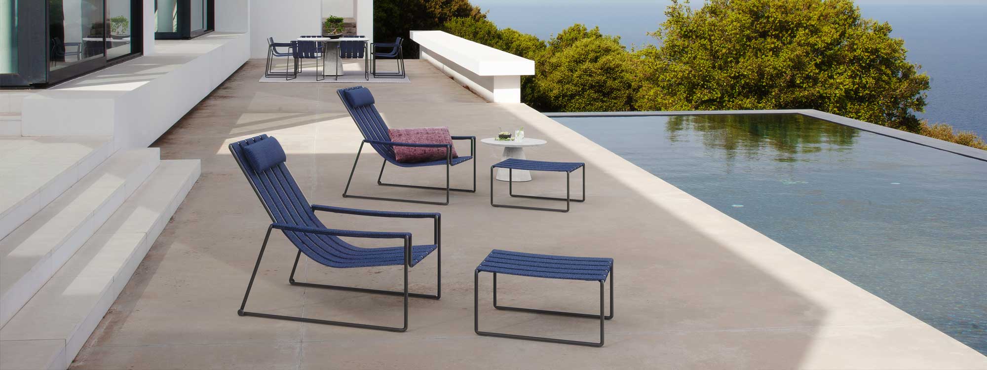 Royal Botania Strappy garden furniture on modern terrace overlooking horizon swimming pool with the coast below