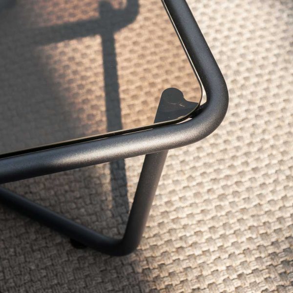 Detail of Sunglass low table's tubular steel frame, with bronze smoked glass table top