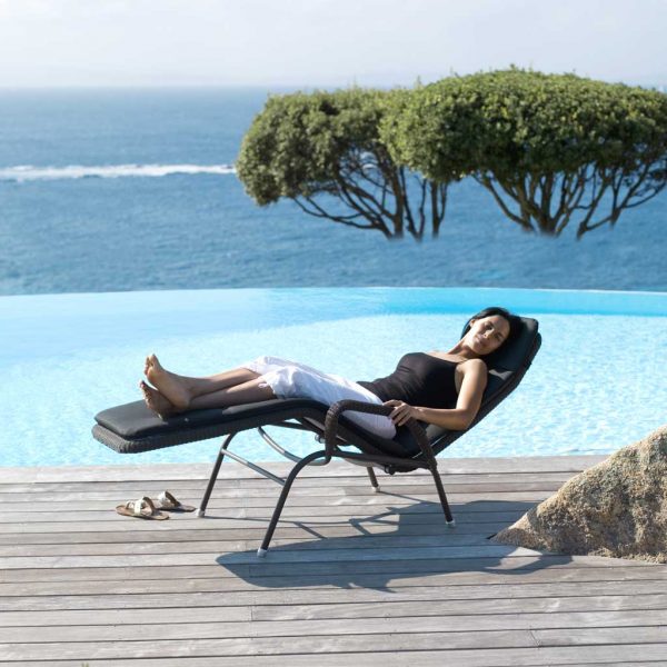 Image of woman relaxing in reclined Sunrise lounge chair by Caneline garden furniture