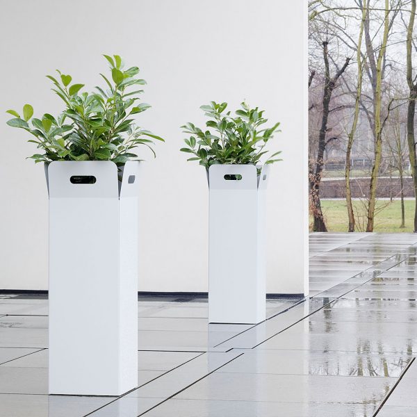 Image of pair of Box tall white planters by Flora, shown on cold and wet wintery terrace