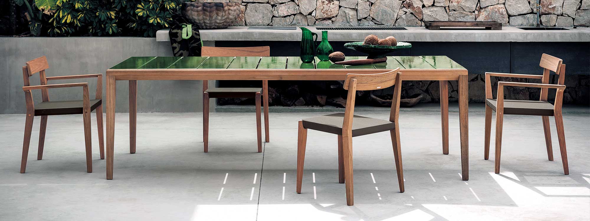 Image of RODA Teka teak dining chairs with Brown Batyline mesh seats, next to Teka teak garden table with Green glazes Gres ceramic table top