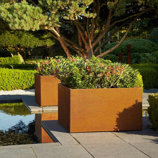 Image of pair of Thallo rusted corten planters beside still water feature