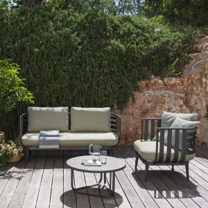 Image on sunny decked terrace of RODA Thea modern 2 seat garden sofa and lounge chair, with circular low table in the center