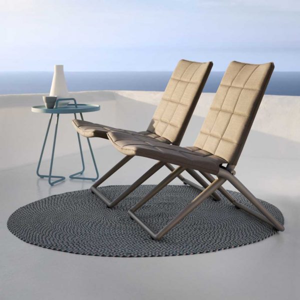 Image of pair of Traveller folding relax chairs by Caneline, shown on circular outdoor rug