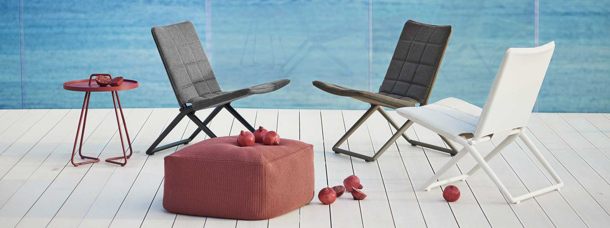 Image of Traveller folding garden lounge chairs, Divine pouf & On The Move side table by Cane-line garden furniture